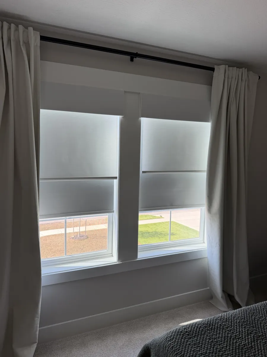 Inside-mount roller shades layered with drapery panels on a double window in a Lewis Center, Ohio bedroom